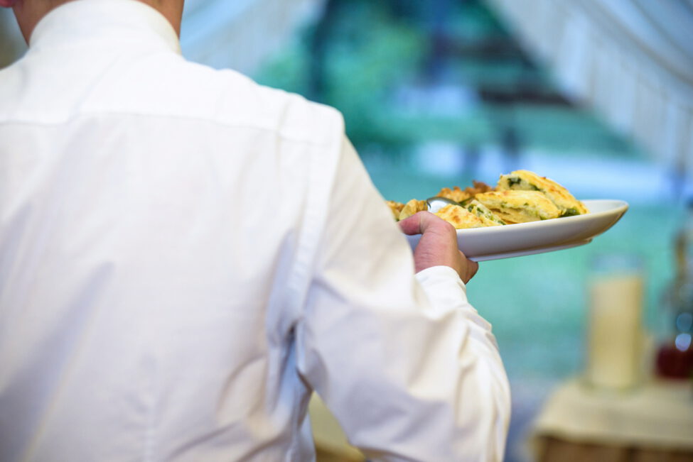Illustrasjonbilde av en kelner som holder en tallerken med mat